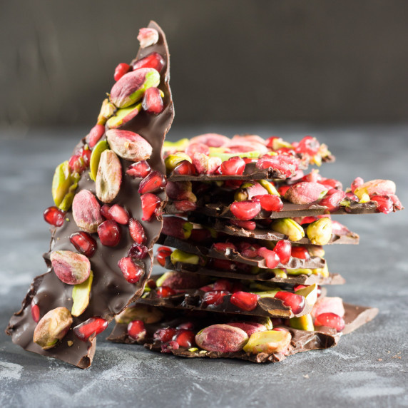 chocolate pistachio pomegranate bark on a dark top