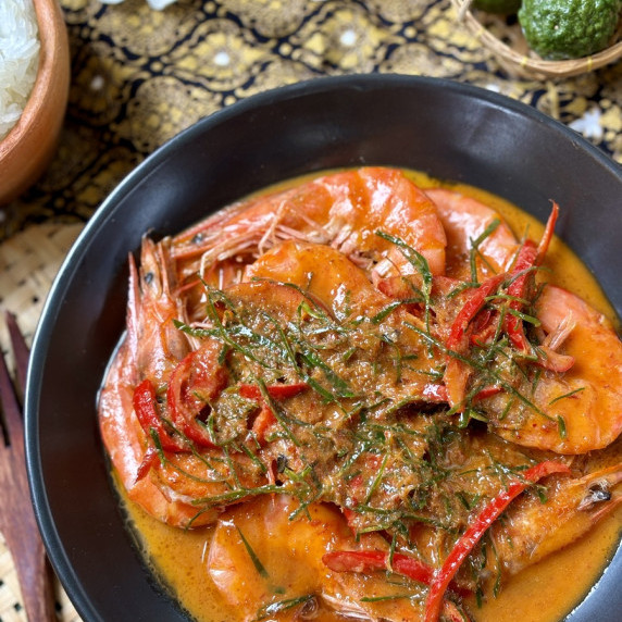 Thai choo chee curry with shrimp served in a black dish.