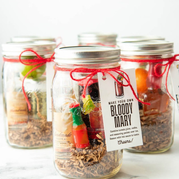 Six DIY cocktail kits in quart sized jars, with a bloody mary kit in front.