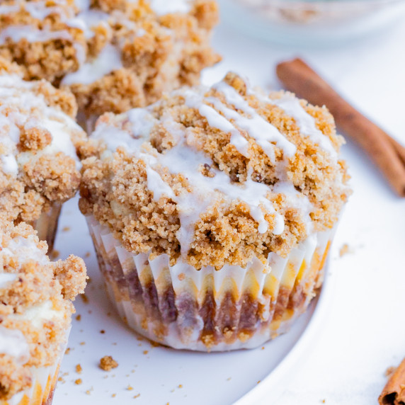 Coffee Cake Muffin RECIPE with muffins arranged on a white plate on a white countertop.