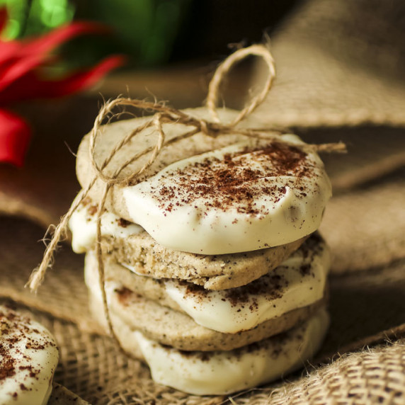 Side close up shot of four shortbread cookies stacked and tied together with a bow of twine.