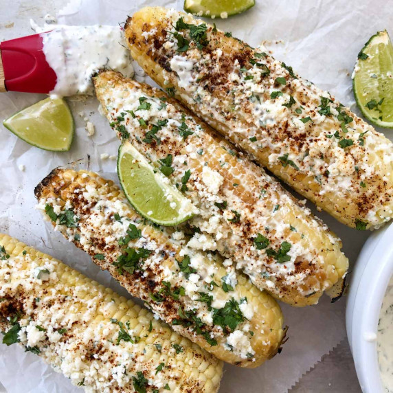 mexican street corn on parchment paper with limes
