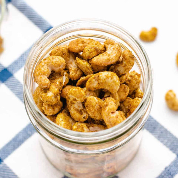 Roasted curry cashews in a glass jar.