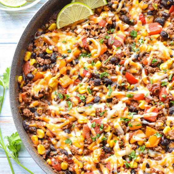 taco skillet with ground beef, veggies, and beans in a large skillet.