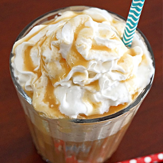 homemade caramel frappuccino in a clear glass with whipped cream 
