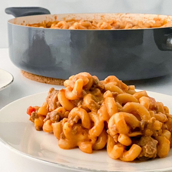 A white plate with a serving of hamburger mac and cheese.