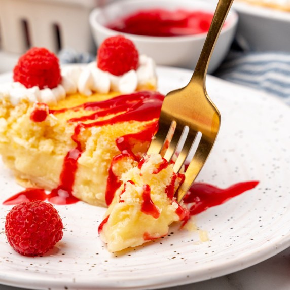 A slice of lemon cake with raspberry sauce.