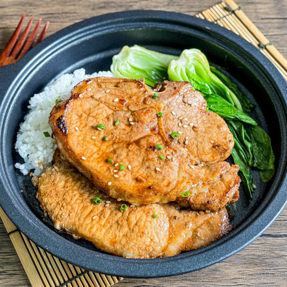 Top-view of hoisin pork chops with blanched choy sum and rice.