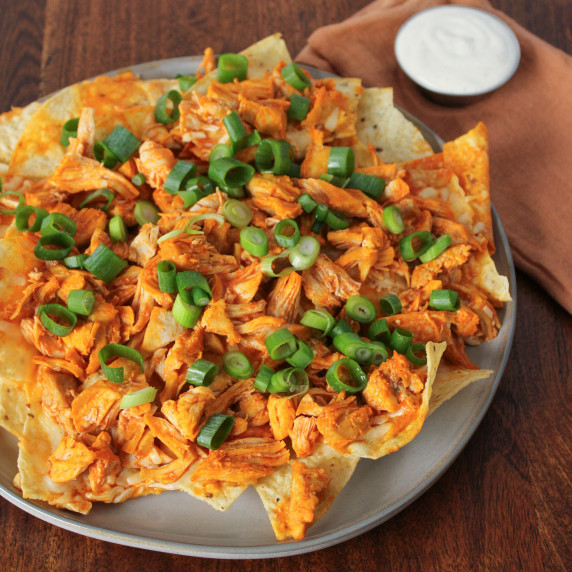 A plate of loaded buffalo chicken nachos