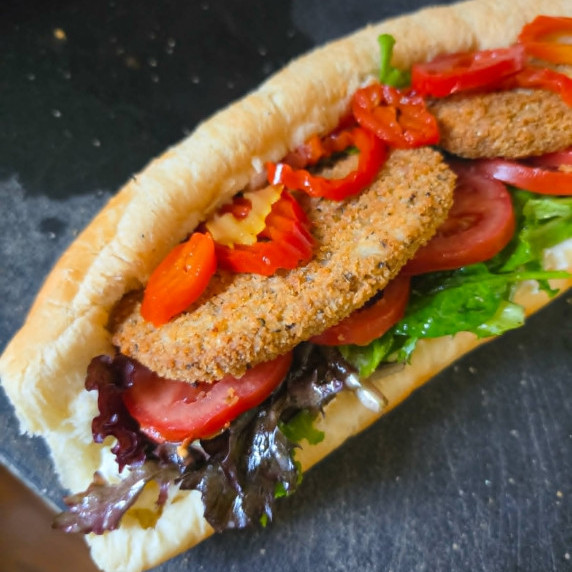 Loaded sandwich with colourful veggies and golden brown cutlets.