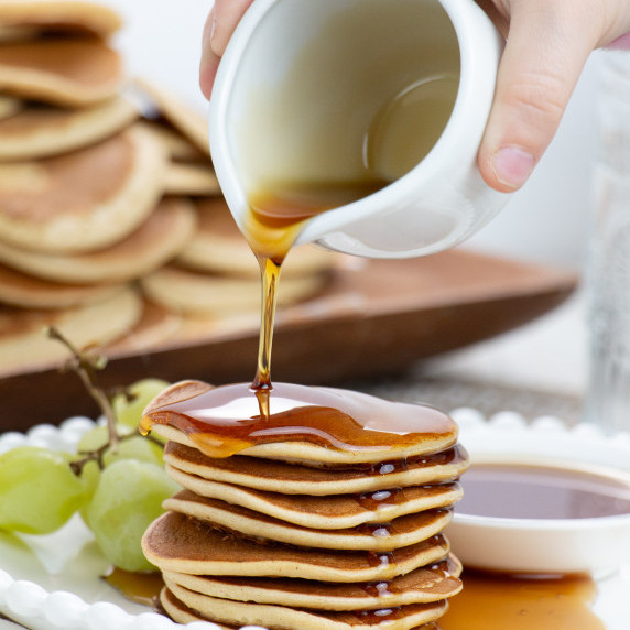 maple syrup pouring over pancakes