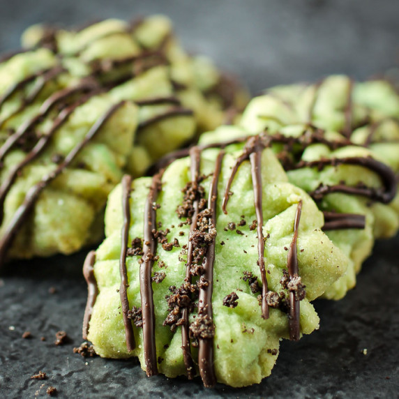 Side close up shot of multiple star shaped shortbread cookies garnished with melted chocolate. 