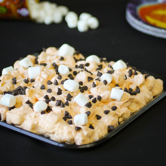 Side shot of monster mash sprinkled with chocolate chips and mini marshmallows on a black plate.