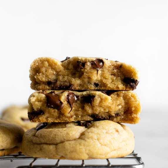 stacked chocolate chip cookies on a cooling rack