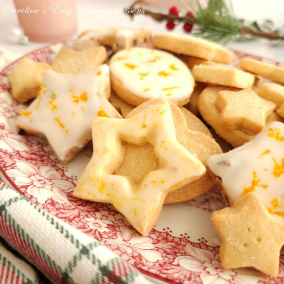 Close shot of orange zest glazed star shaped cut out Scottish shortbread on plate.
