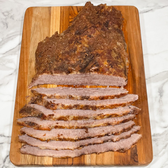 slow cooked brisket sliced on a cutting board