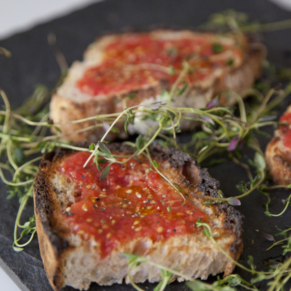 Crispy Sourdough Bread topped with Tomato Puree, Maldon Salt, Pepper and Olive Oil