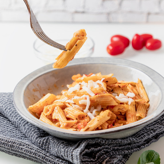 pink sauce pasta in a grey bowl with mozzarella cheese