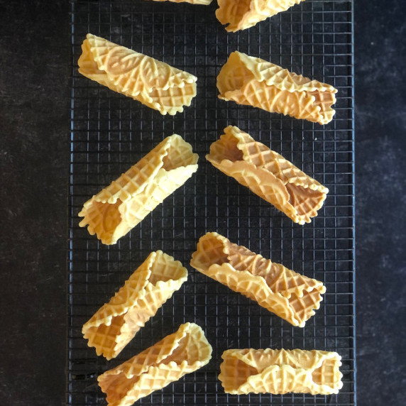 cannoli shells sitting on a cooling rack
