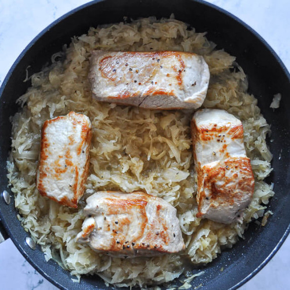 Overhead photo of grandma’s pork and sauerkraut in a skillet.