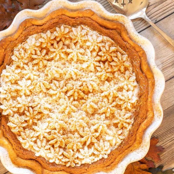 Overhead of Pumpkin Chiffon Pie on wood background with pie server on the side