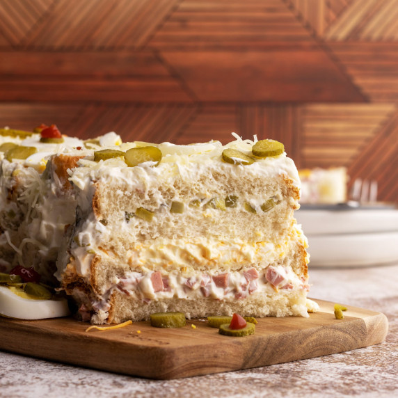 Savory sandwich cake on a wooden board