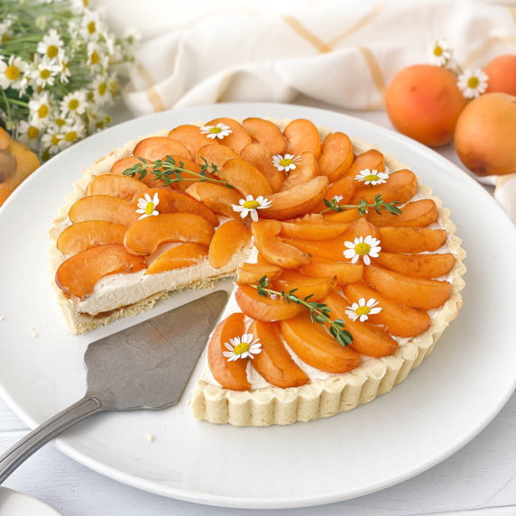 Apricot Tart on a white plate with a slice missing.