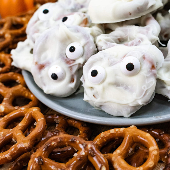 White chocolate covered pretzel mummy on a grey plate