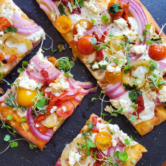 A colourful flatbread with a black background.