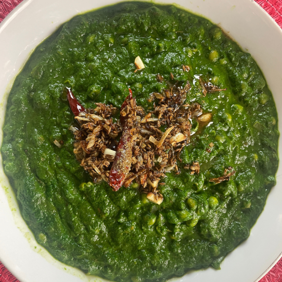 spinach with peas in a white bowl