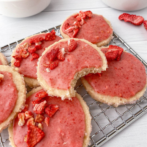 Stack of Strawberry Shortbread Cookies with strawberry glaze on a cooling rack.