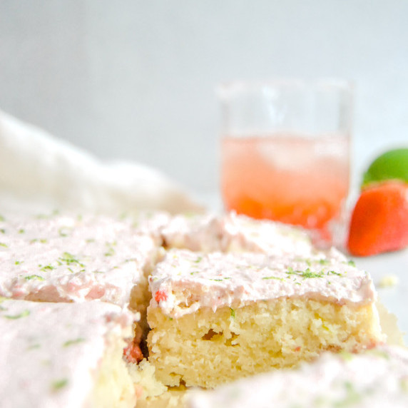slice of strawberry margarita sheet cake on marble background