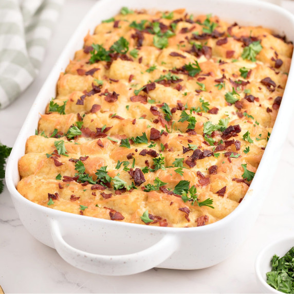 Tater tot breakfast casserole in a white baking dish.