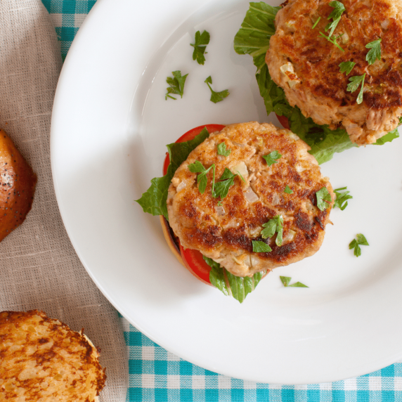 Air fryer tuna patties arranged on a white plate with parsely sprinkled over top