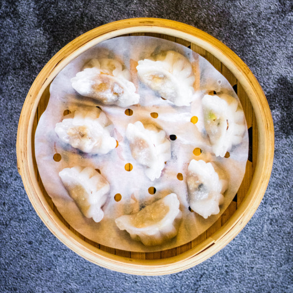 overhead shot of vegetarian crystal dumplings in a bamboo steamer.